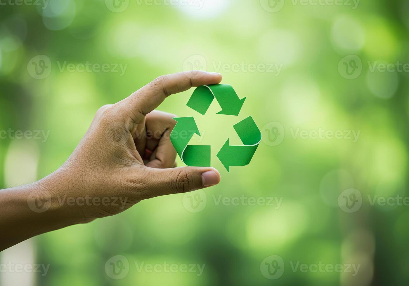 Hand holding recycling symbol on green background photo