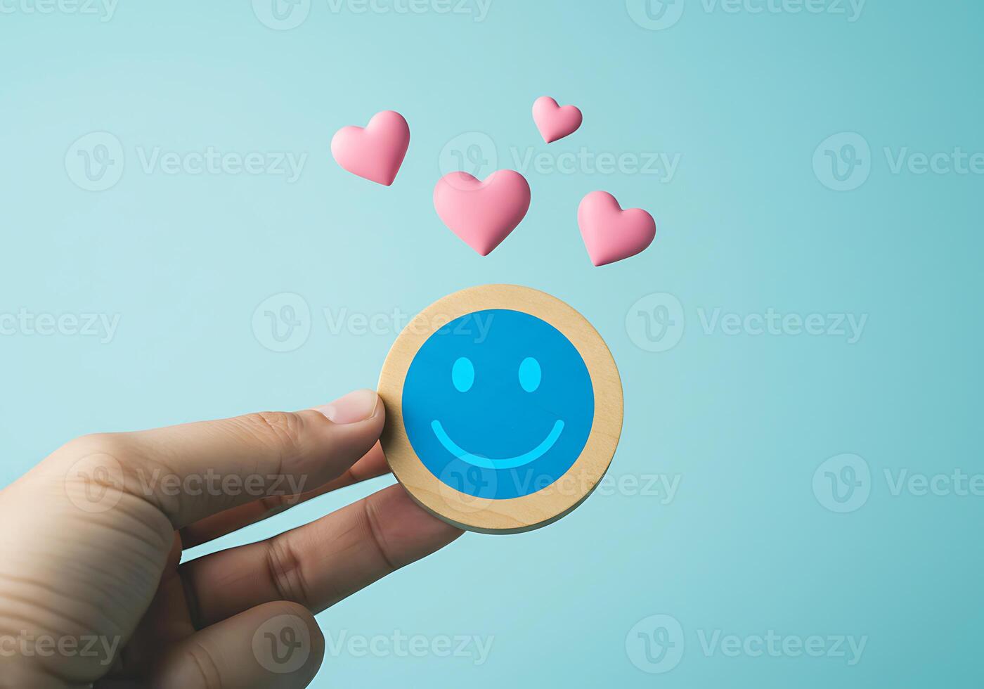 Hand holding a smiley face with hearts on blue background photo