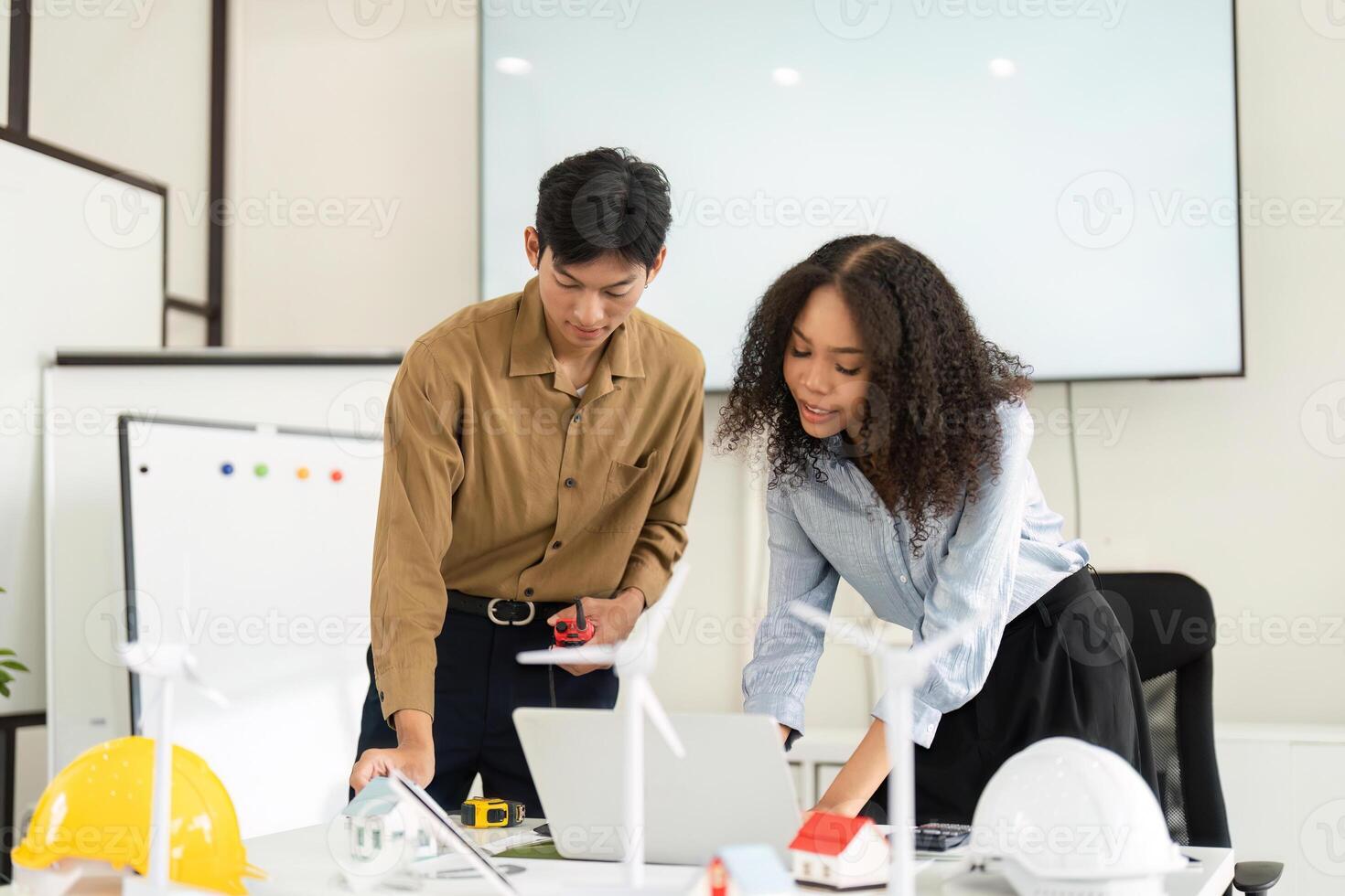 Collaboration in Renewable Solutions. A focused team working on innovative designs in a modern office setting. photo