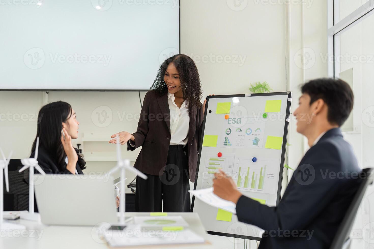 Sustainability Dialogue and ESG Metrics. A diverse team collaboratively discusses ESG performance in a stylish office setting. photo