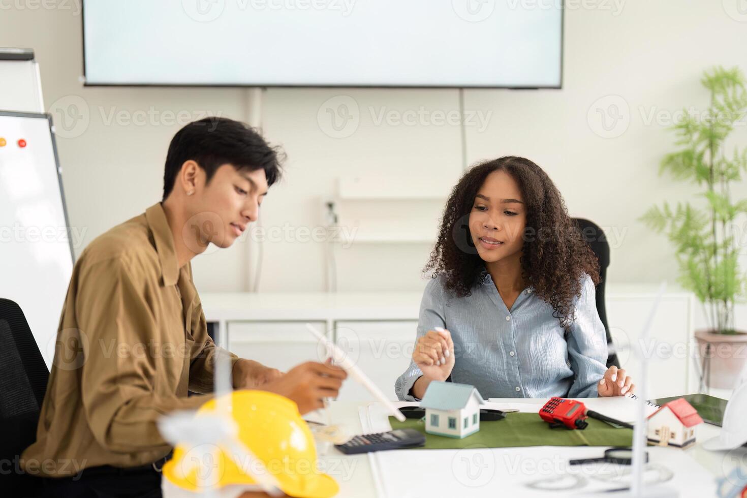 Sustainable Solutions and Creative Collaboration. Professionals examining architectural models in a shared workspace. photo