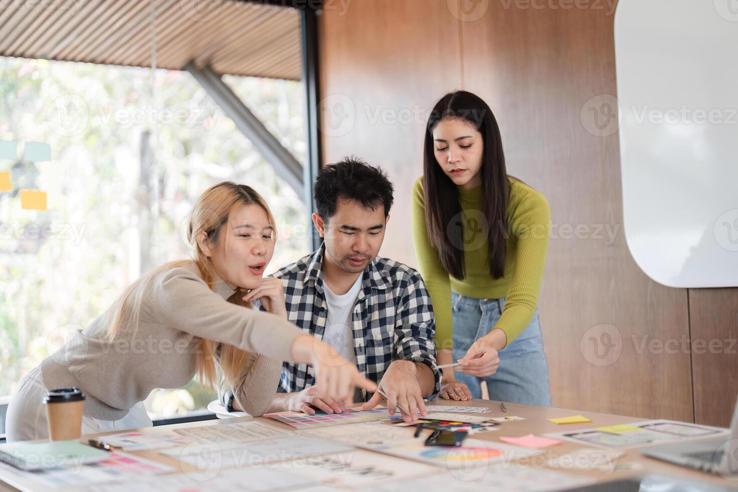 Diverse team collaborating on creative project in modern office space. photo