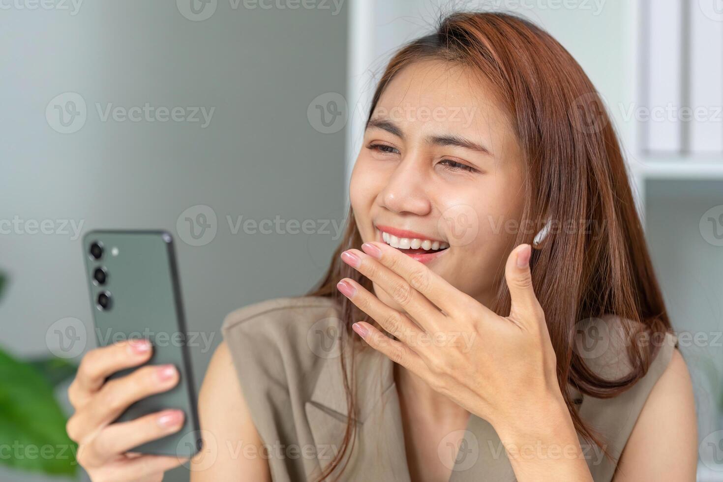 Joyful Communication and Engagement. A woman reacts happily while viewing content on her smartphone. photo