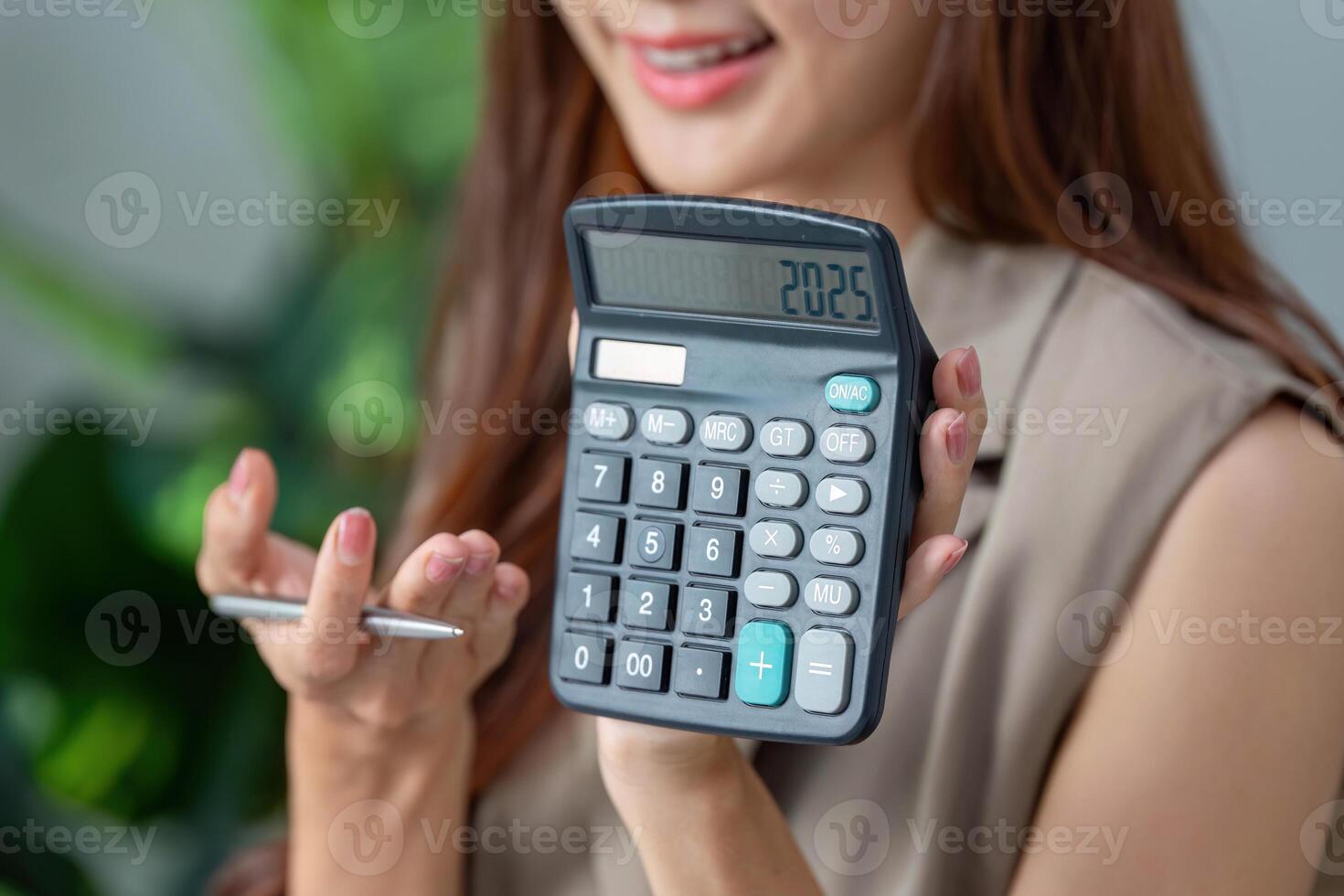 Calculator Insights and Financial Planning. A woman revealing her calculator displaying a financial figure. photo