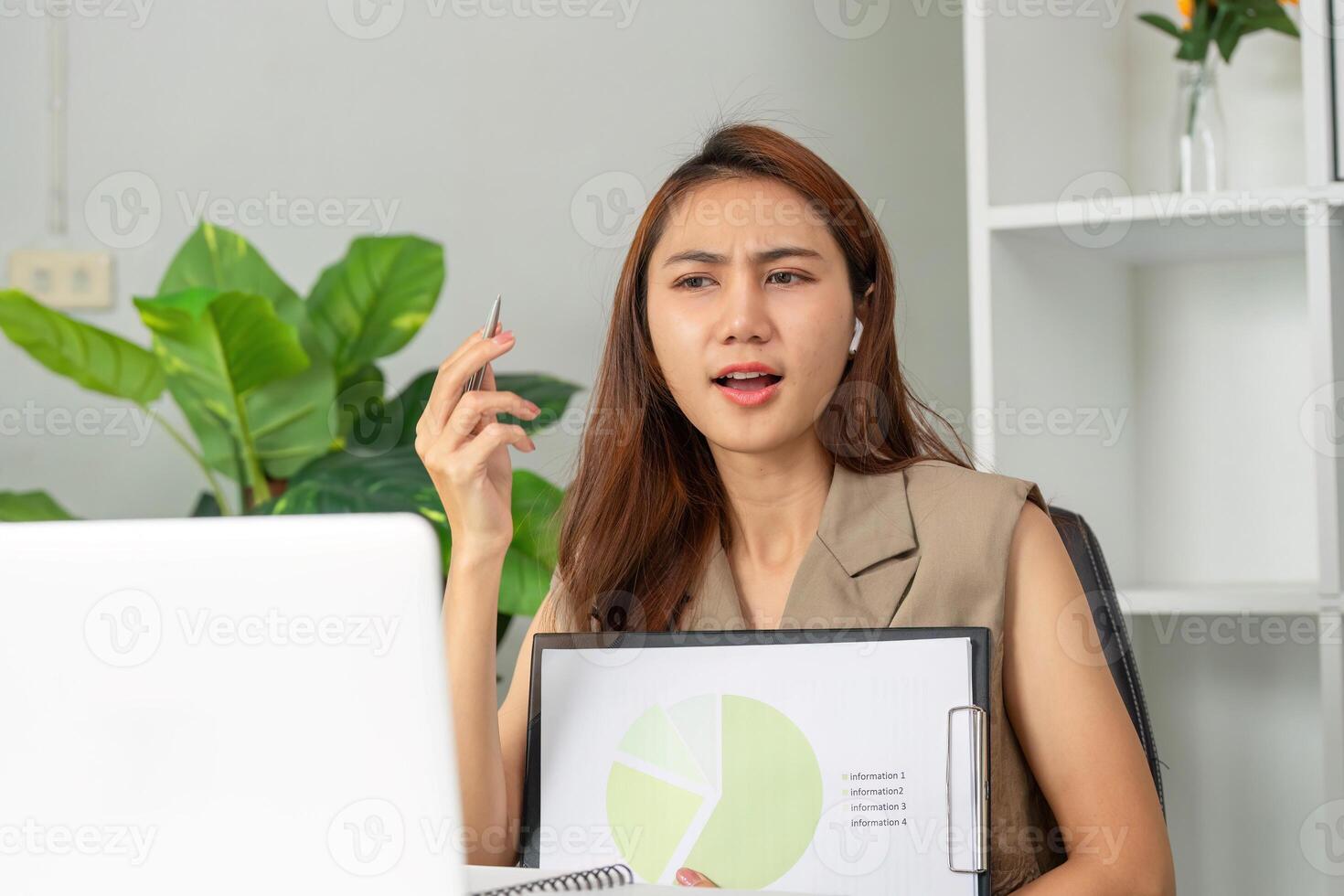 Data Interpretation and Engagement. A young woman presents her findings while using a laptop during a call. photo