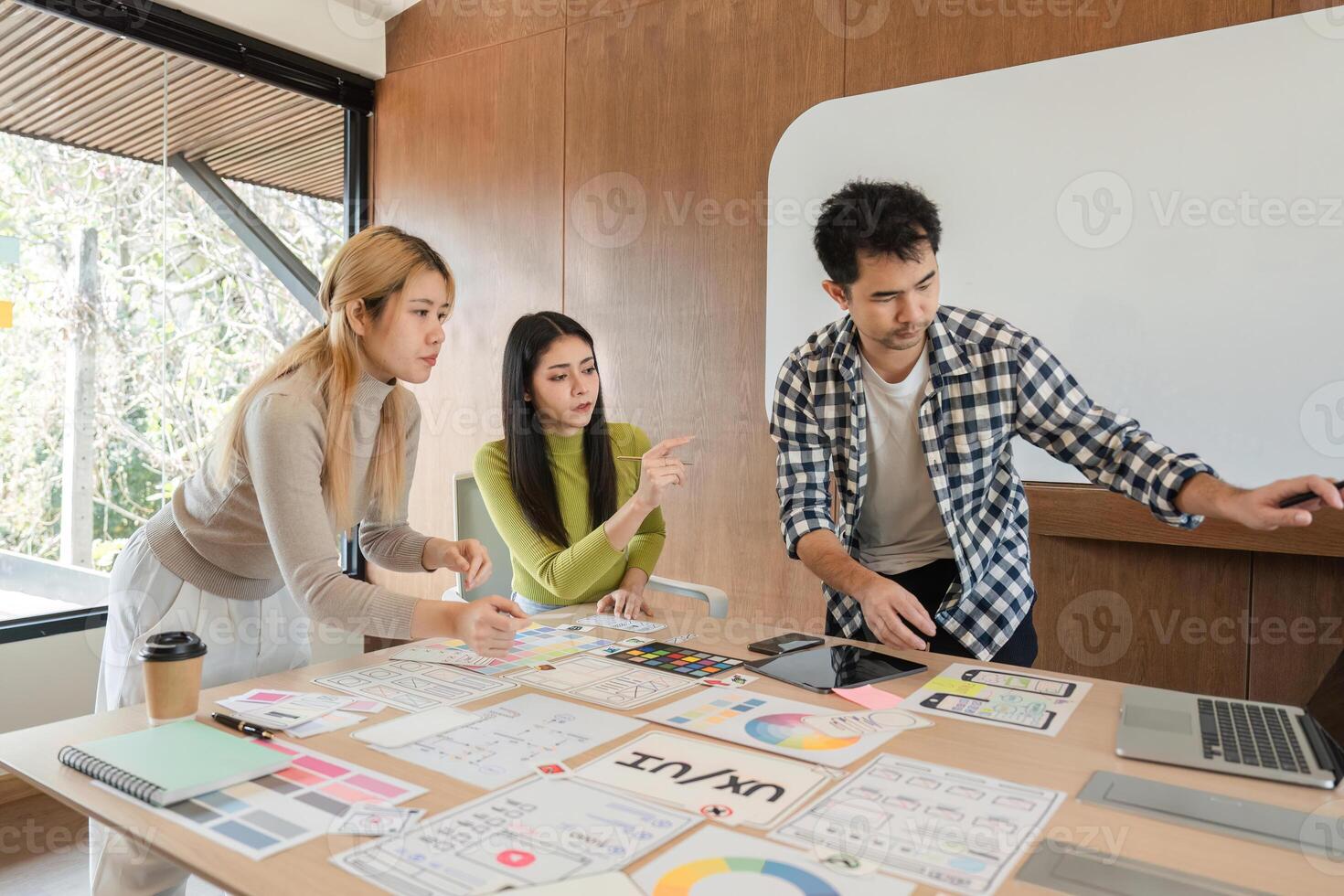 Diverse team of designers collaborating on UX UI project in modern office. photo