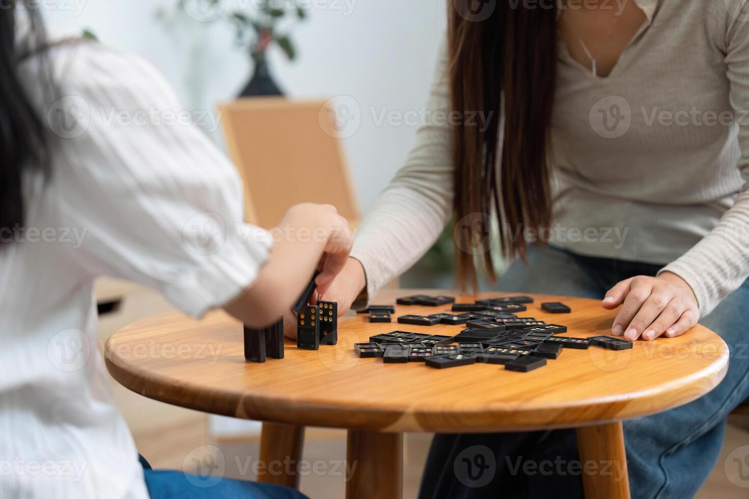 Creative Play and Learning. A mother and daughter engaged in a game of dominoes, fostering connection and learning. photo
