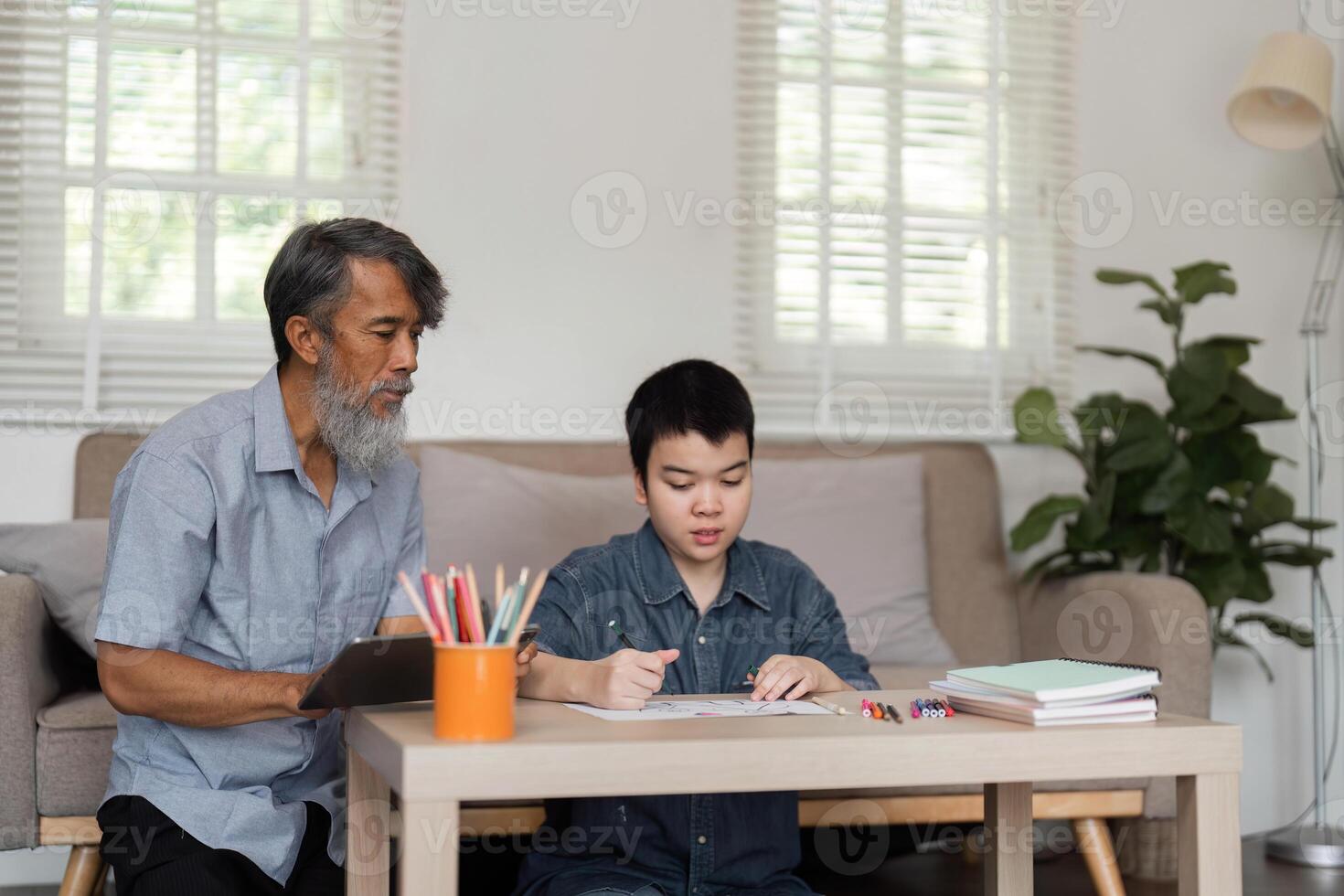 Guided Learning and Creativity. A grandfather overseeing a child during a drawing session. photo