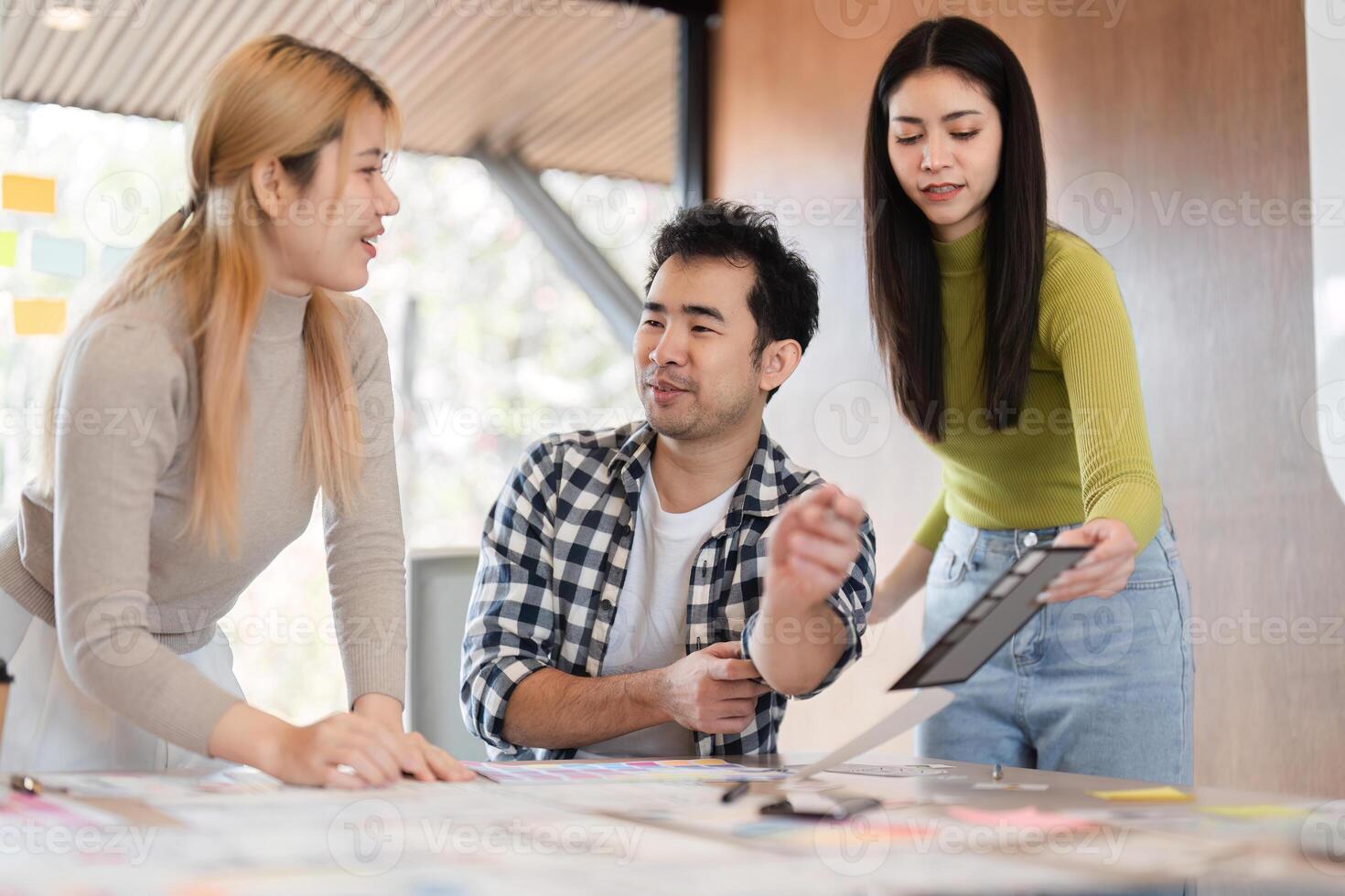 Diverse professionals discussing ideas and reviewing documents in office. photo