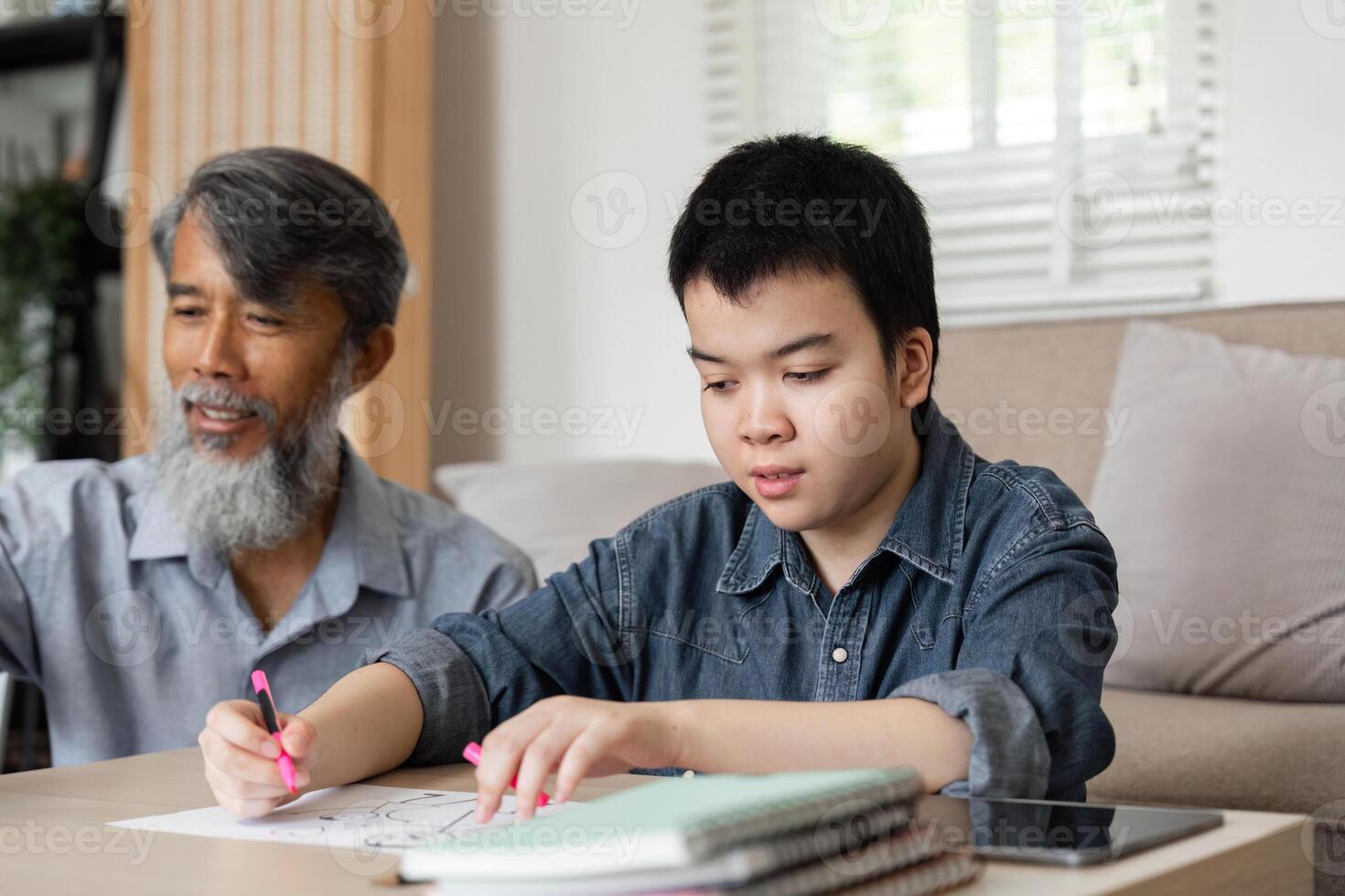 Creative Learning and Family Bonding. A grandfather and grandson engage in art activities at home, fostering creativity and connection. photo