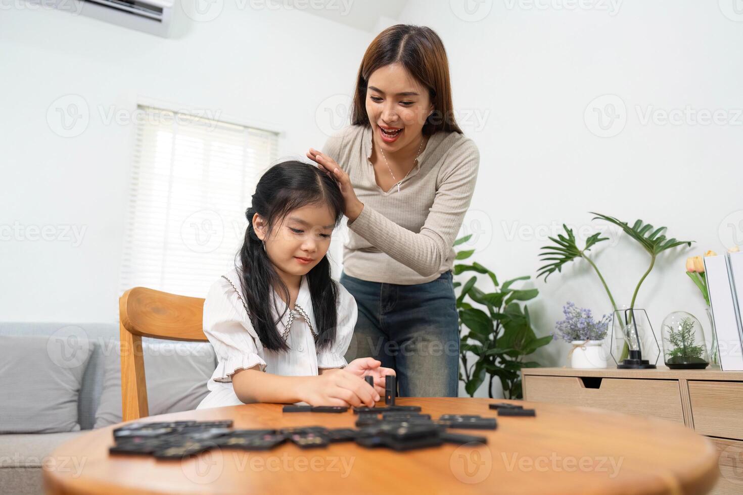 Family Bonding and Playtime. A mother and daughter enjoying a playful moment while learning through a fun game. photo
