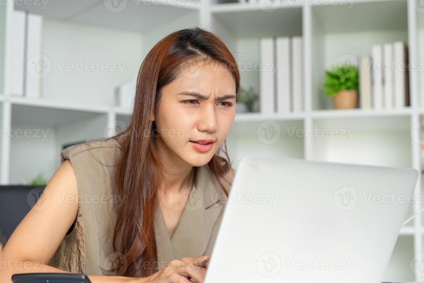 Focused Work and Data Evaluation. A woman intensely reviewing data on her laptop screen. photo