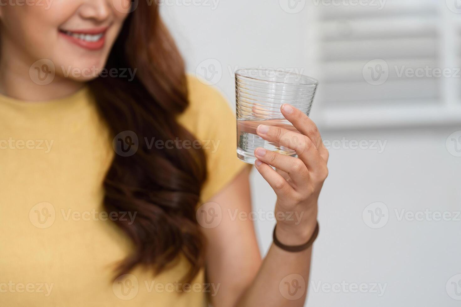 Morning Routine and Smiles. A woman cheerfully enjoying a refreshing drink as part of her morning routine. photo