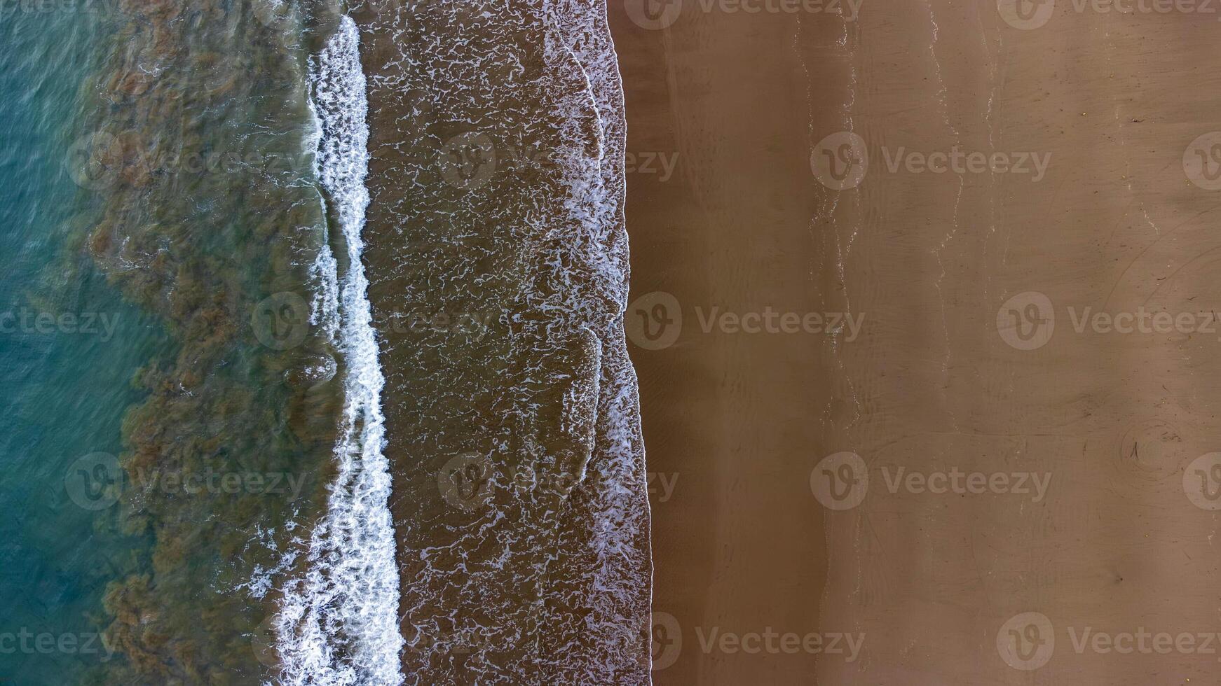 Aerial View of Waves Crashing on Sandy Beach, Beautiful Beach at Lenggoksono Beach photo