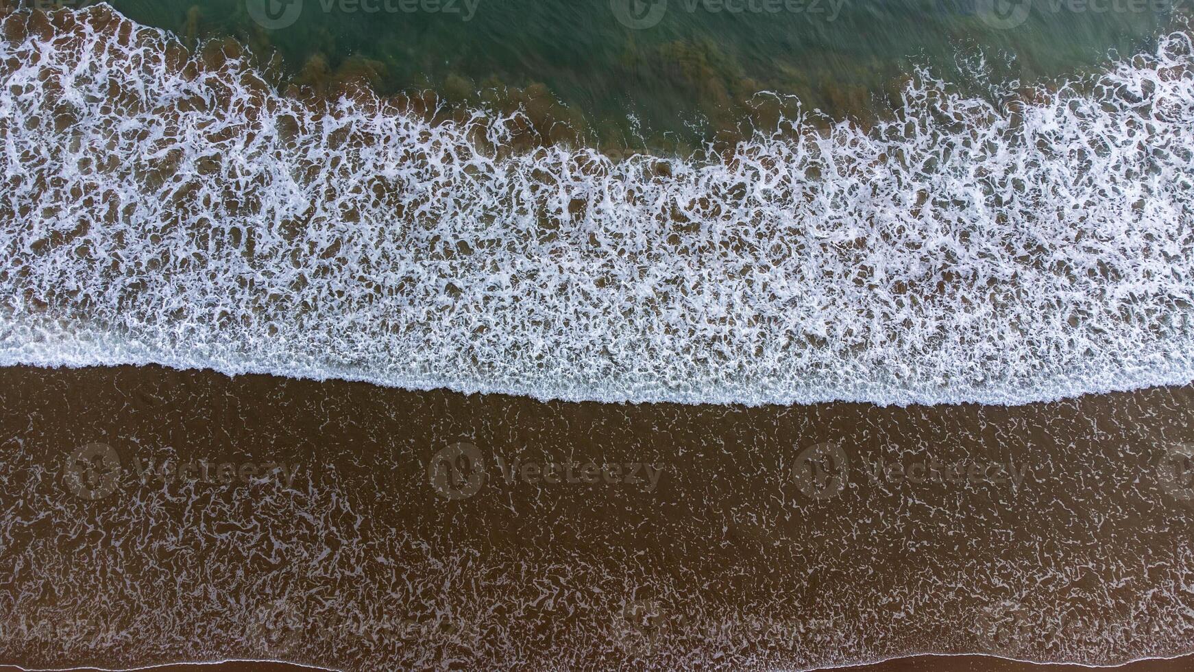 Aerial View of Waves Crashing on Sandy Beach photo