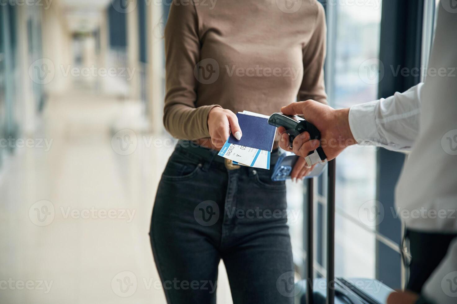 Airport worker is checking tickets of female tourist. Close up view photo