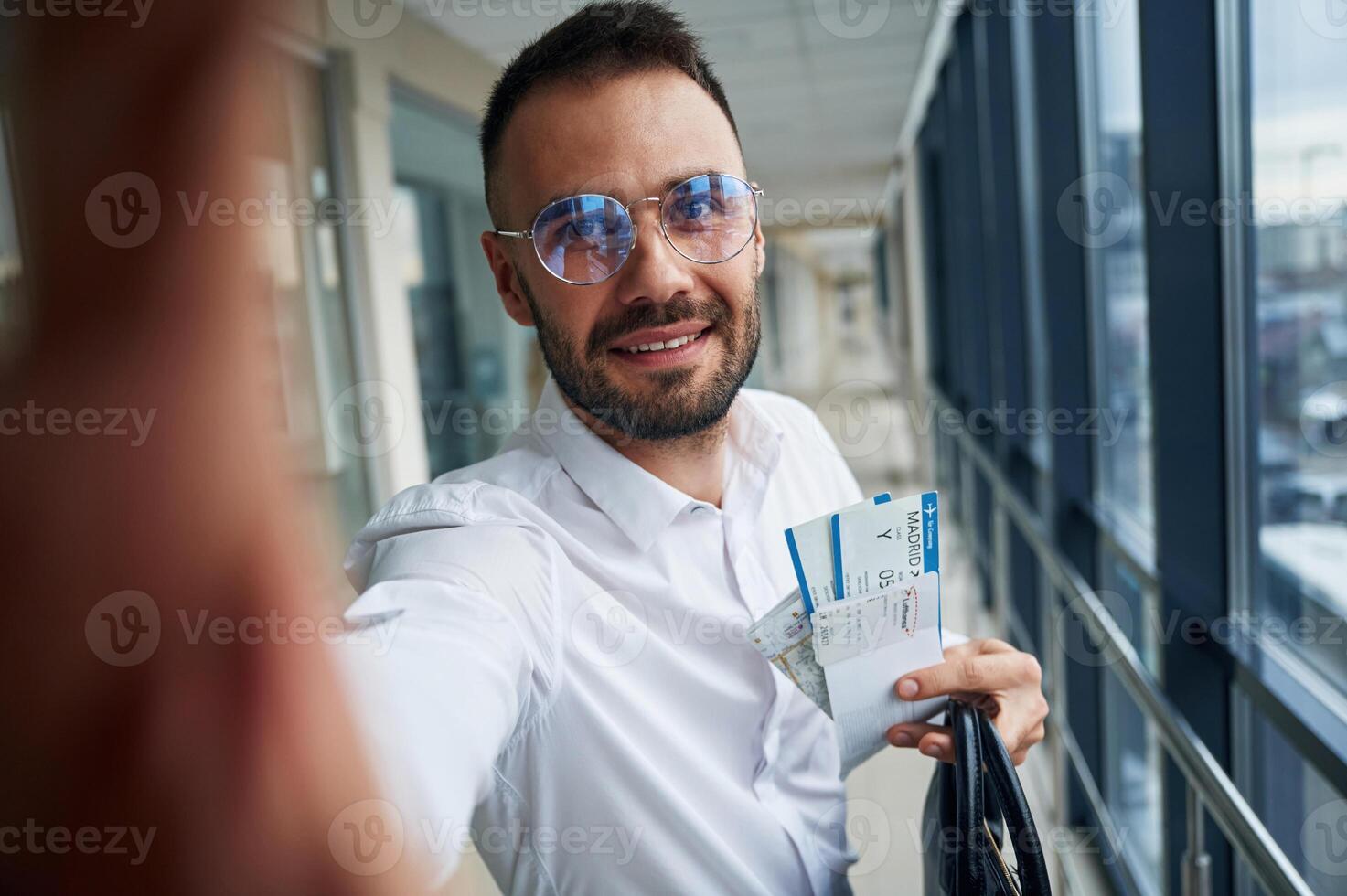Making ,selfie, happy, facial expression. Young handsome man in the airport photo