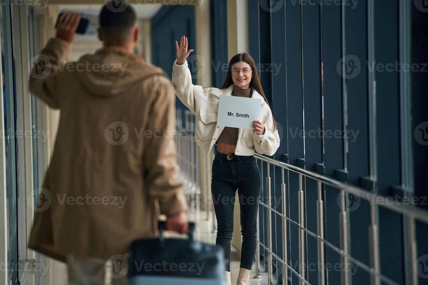 Greetings, gesture, arrival of the man. Couple are in the airport hall together photo