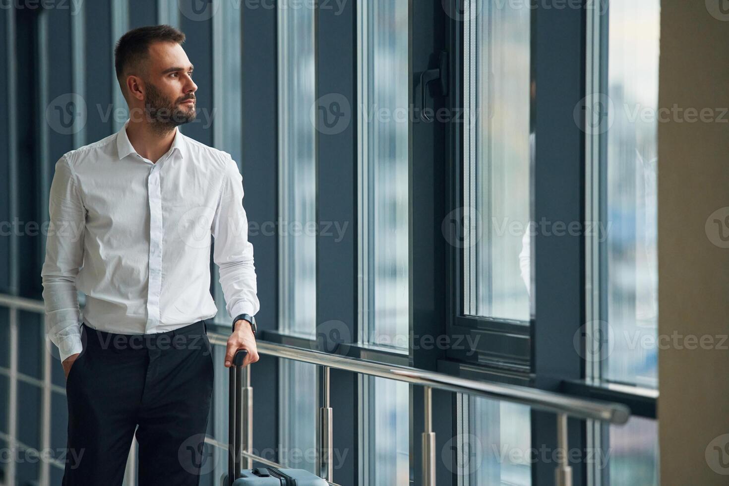 In white shirt ,and black pants, formal clothes. Young handsome man in the airport photo