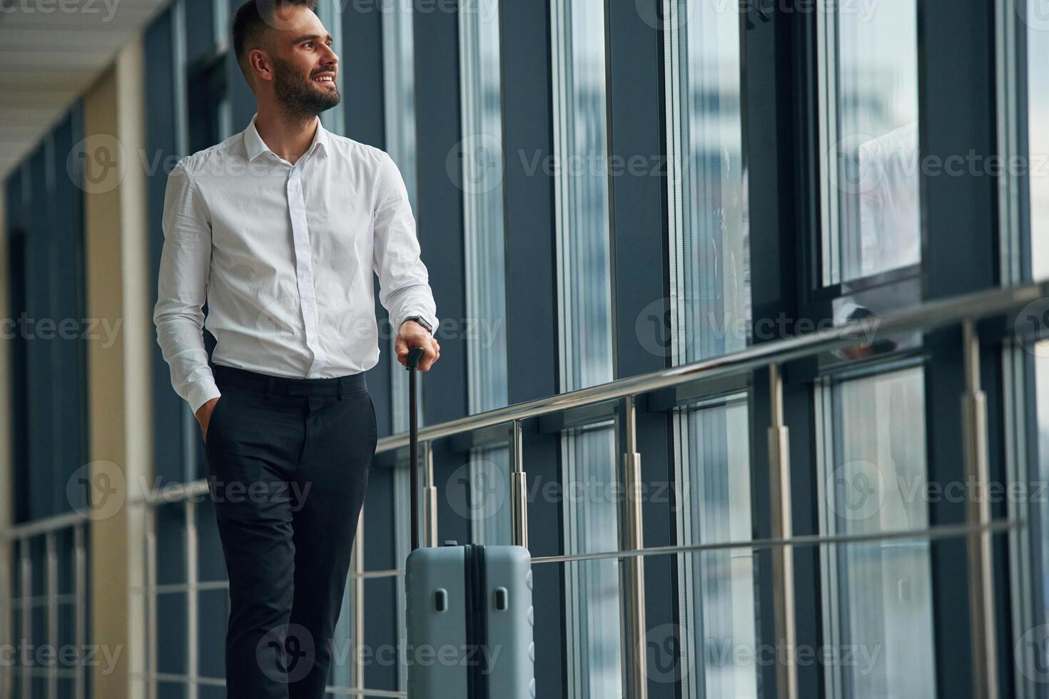 Standing, looking through ,the windows. Young handsome man in the airport photo