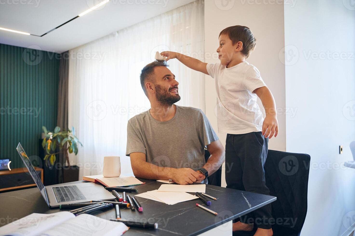 Father, and son are at home by the table photo
