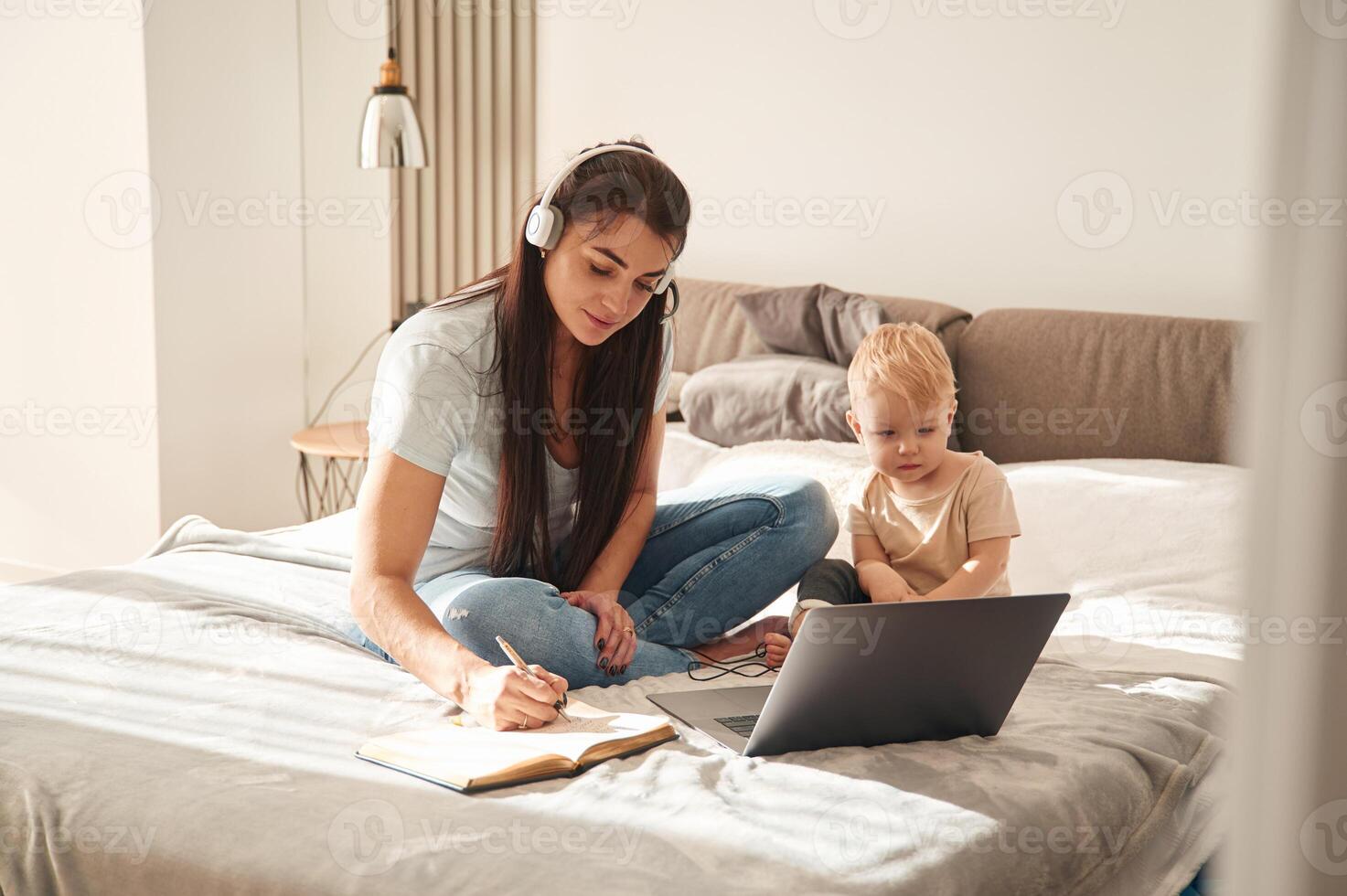 Showing laptop. Mother with her little ,son is at home in domestic room photo