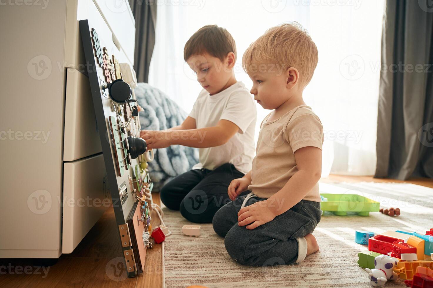 Two ,brothers ,are playing with constructor with bunch of objects at home photo
