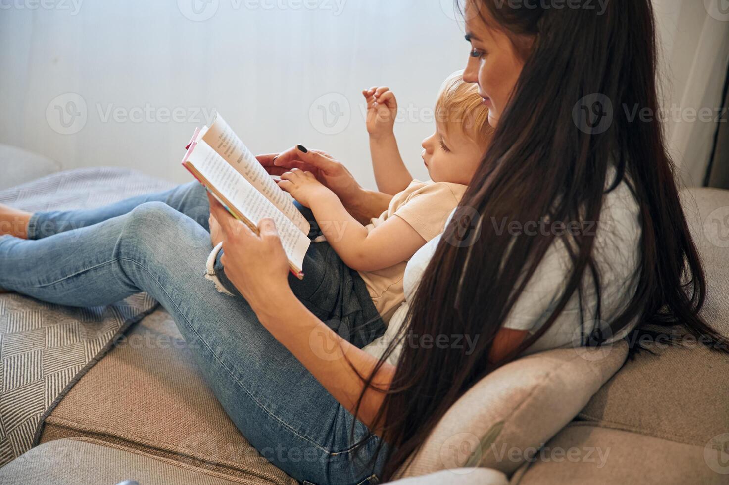 On ,the, legs of woman. Mother with her little son is at home in domestic room photo