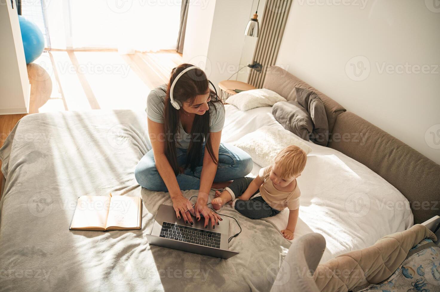 Showing, laptop. Mother with her little son is at home in domestic room photo