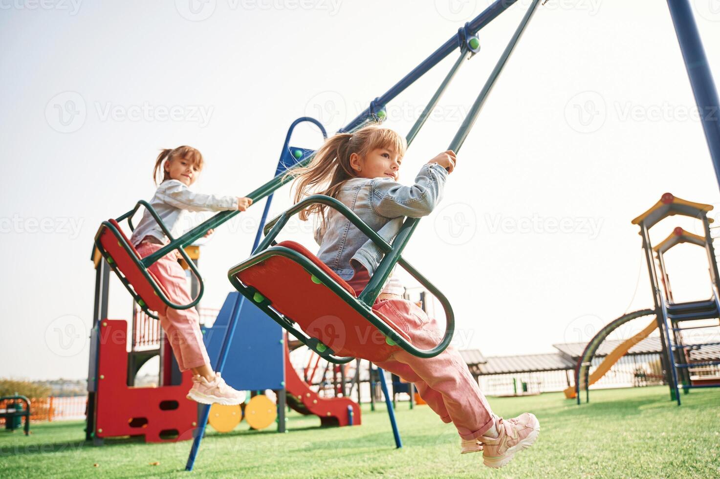 Enjoying swing ride. Kids are having fun on the playground photo