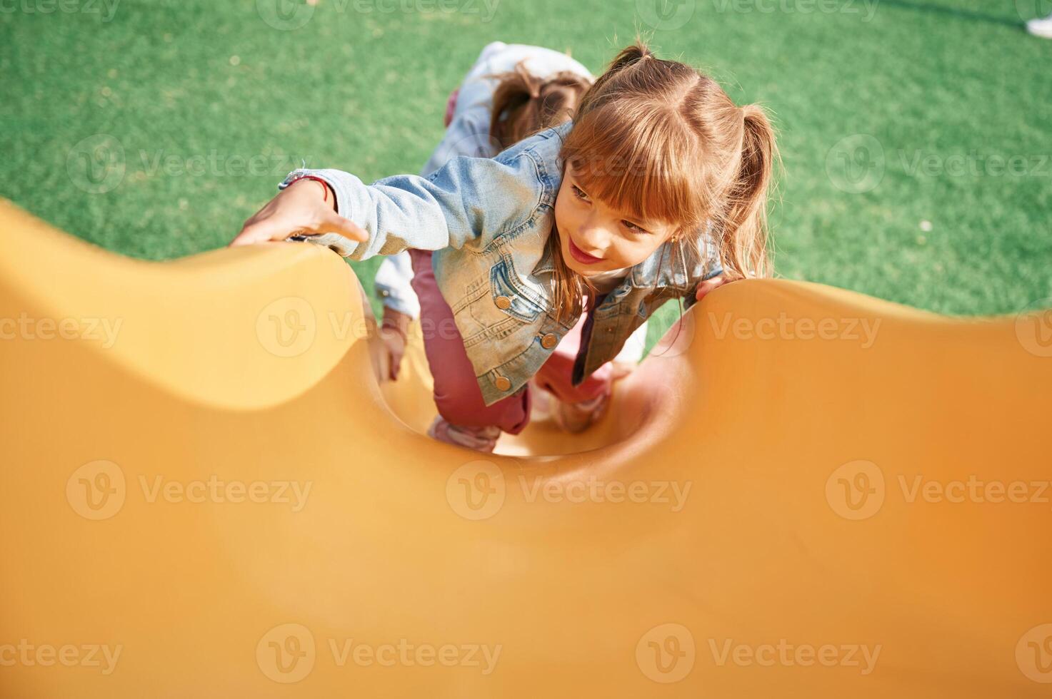 On a playground slide. Little girl is having ,,fun on photo