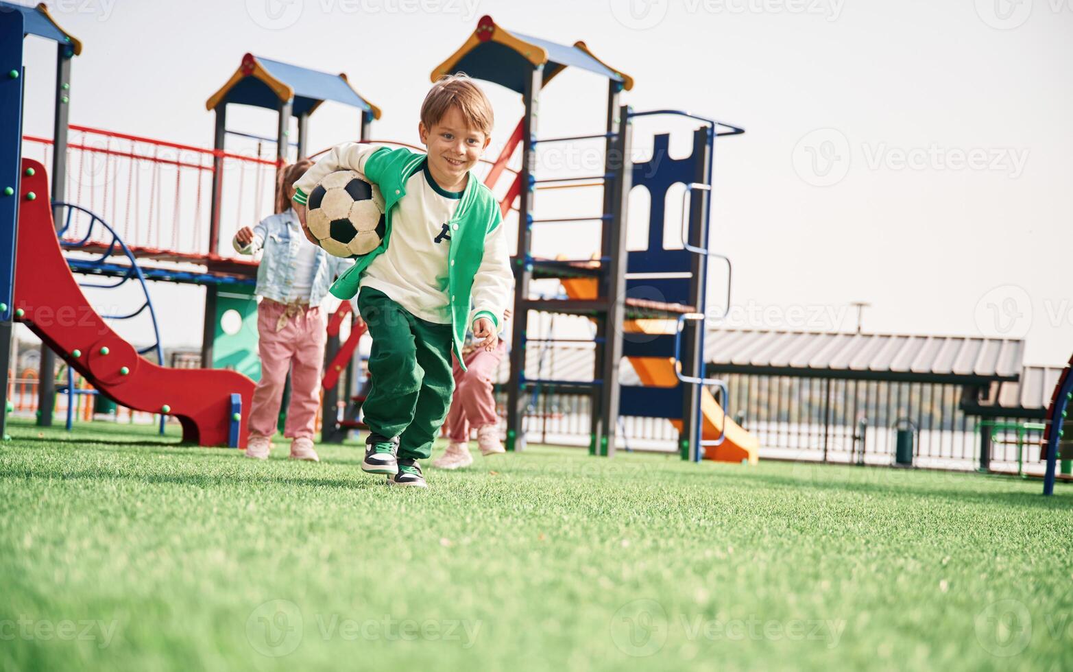Boy is ,with soccer ball. Kids are having fun on the playground photo