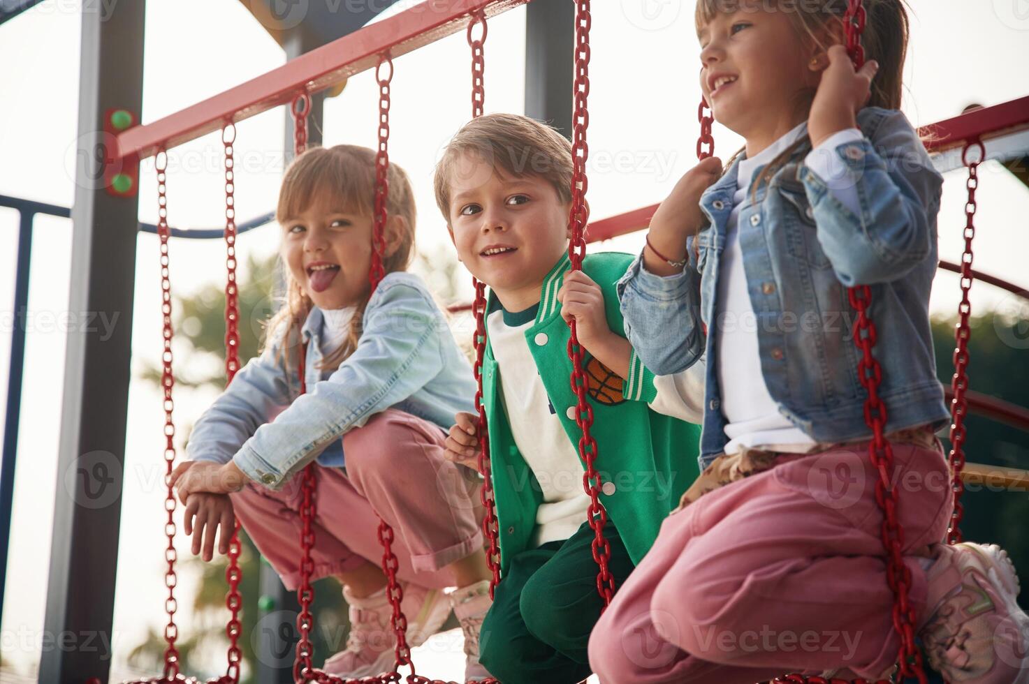 Two girl and one boy. Kids are having,, fun on the playground photo