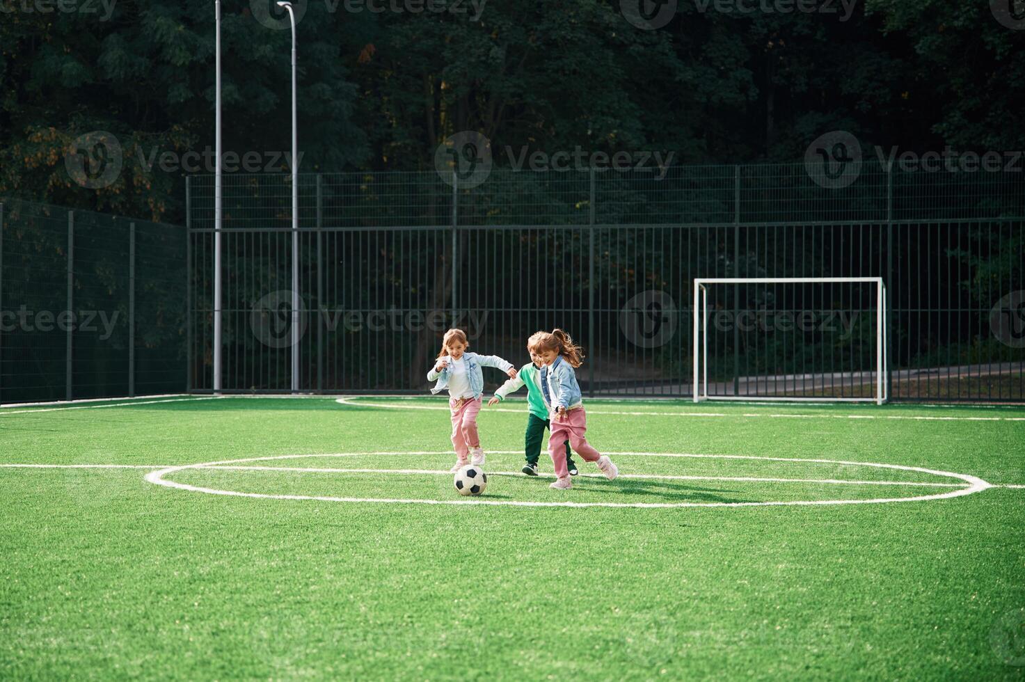 Running with ball. Kids, are, having fun on the green soccer field together photo