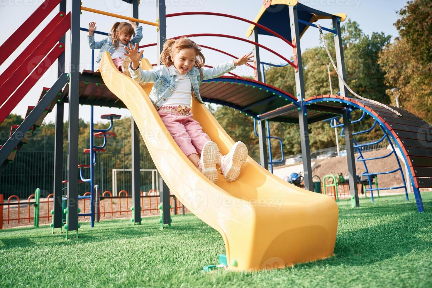 On the playground slide.,, Kids are,, having fun photo