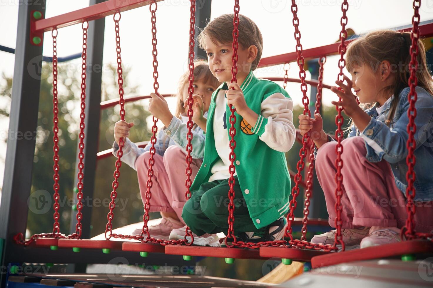 Two ,girl and ,one boy. Kids are having fun on the playground photo