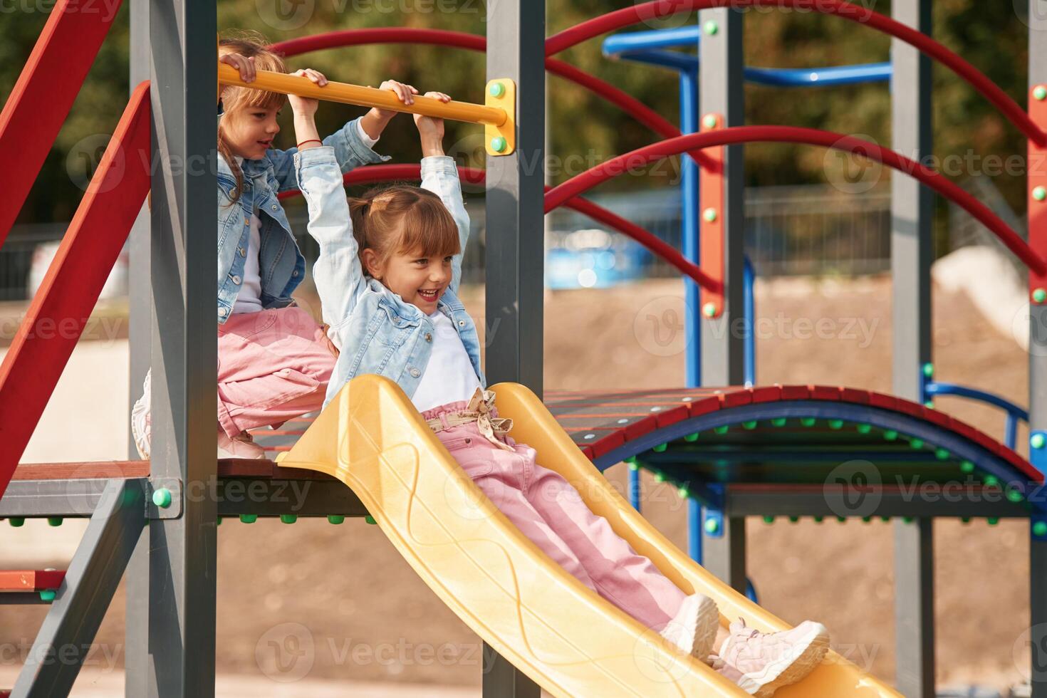 On ,a playground slide. Little girl is having fun on photo