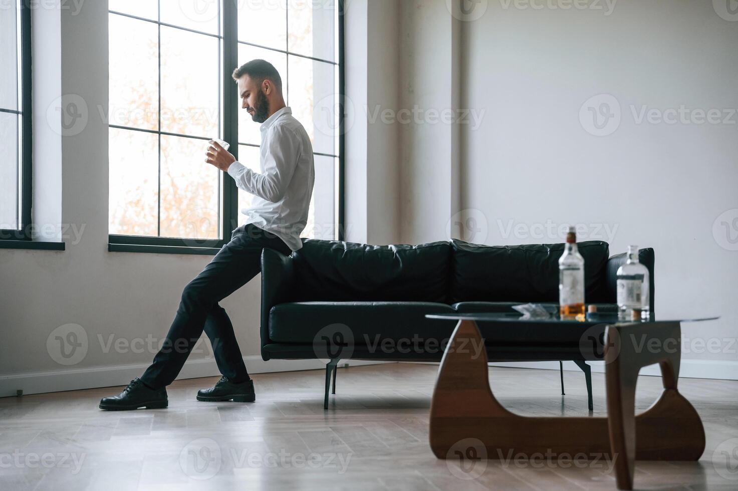 In formal, clothes. Business, failure. Upset, young man drinker alcoholic is indoors photo