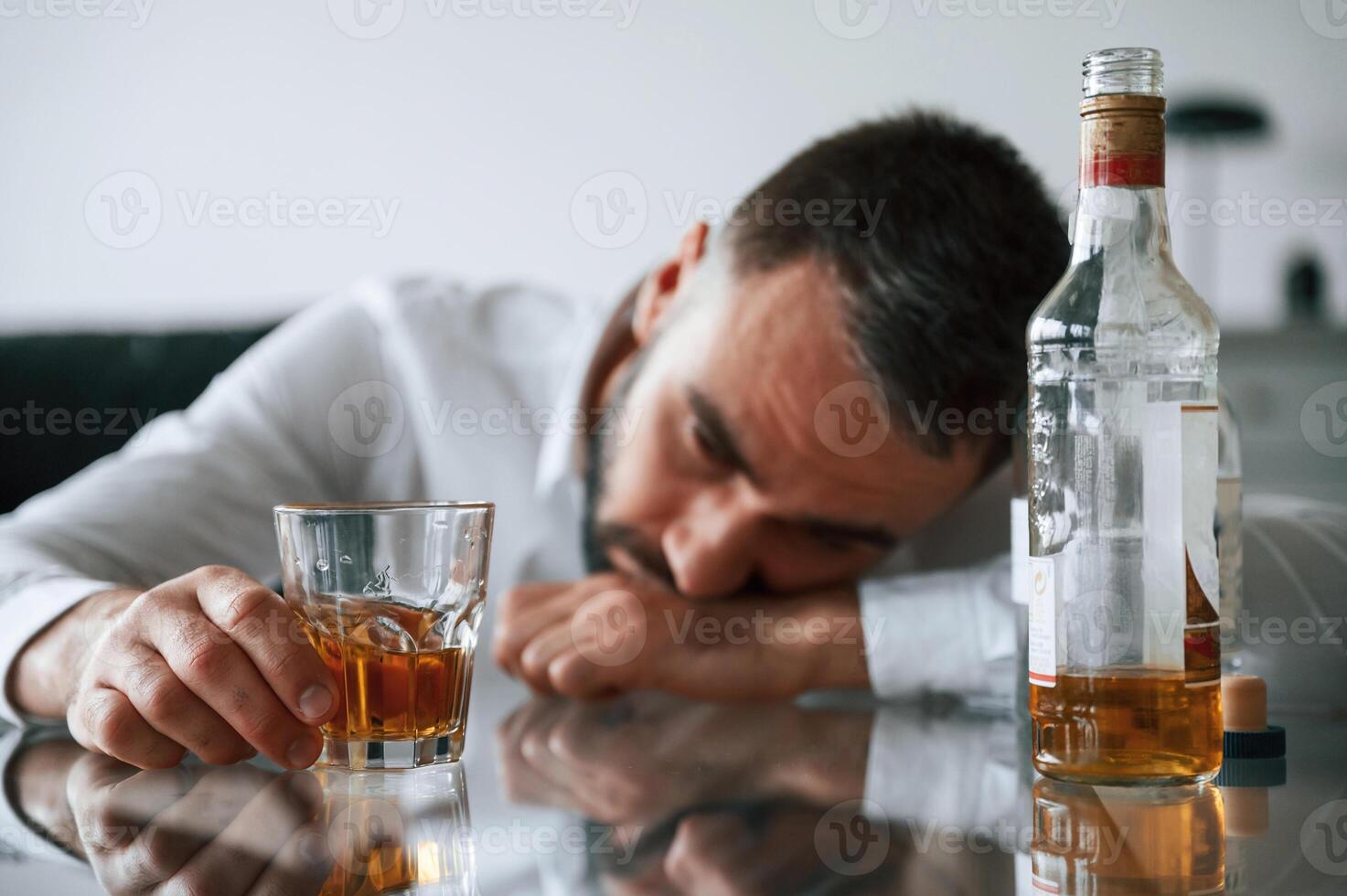 Conception of addiction. Upset,, young man drinker alcoholic is indoors photo