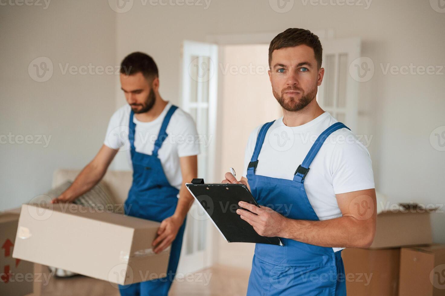 Document in,, hands. Two moving service employees in a room photo
