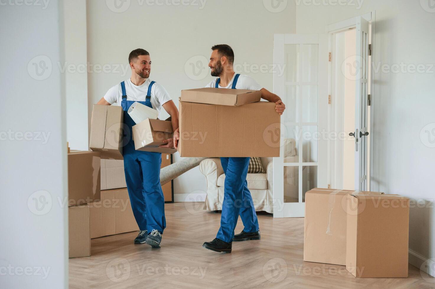 Boxes in hands. Two ,moving service employees in a room photo