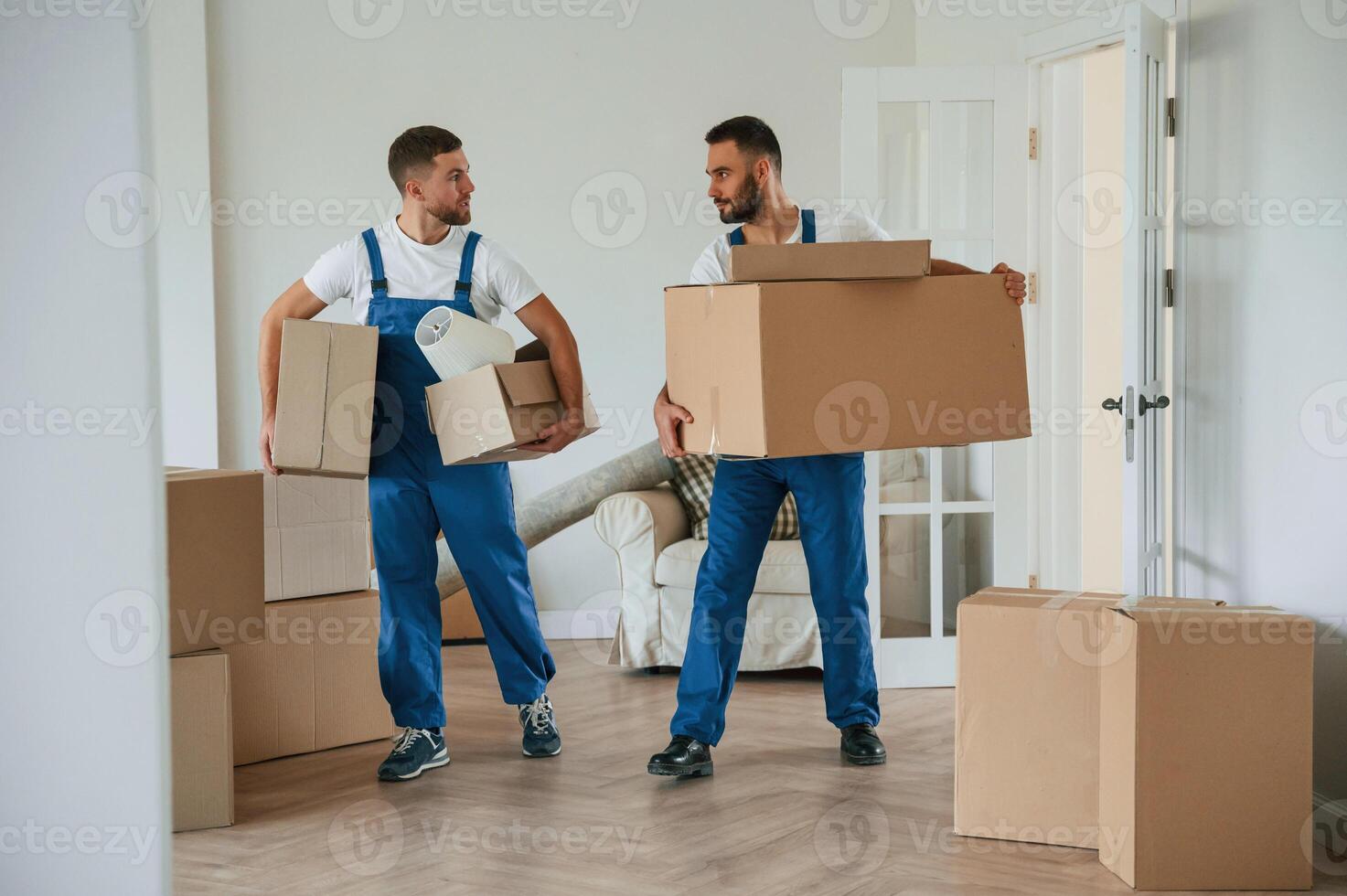 Boxes in hands. Two moving, service employees in a room photo