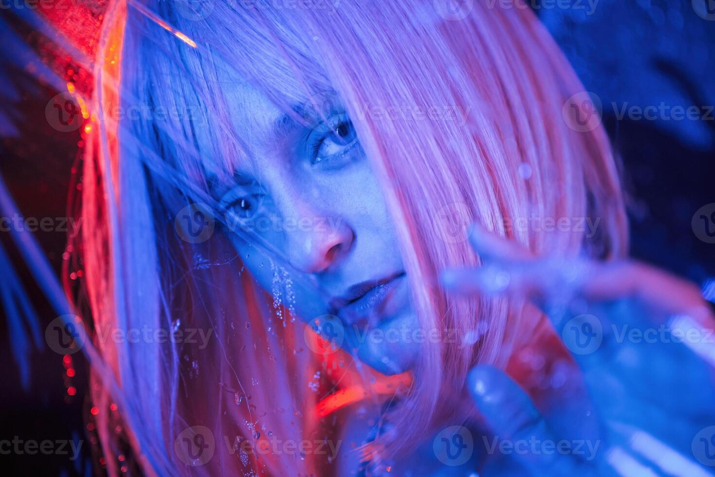 Posing, for ,camera. Stylish woman with white hair is behind wet transparent plastic sheet photo