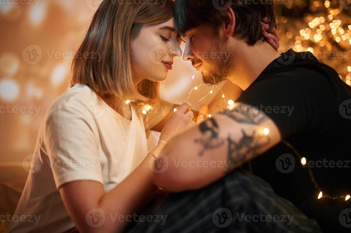 Conception of, love... Beautiful young couple indoors, celebrating new year against projector photo