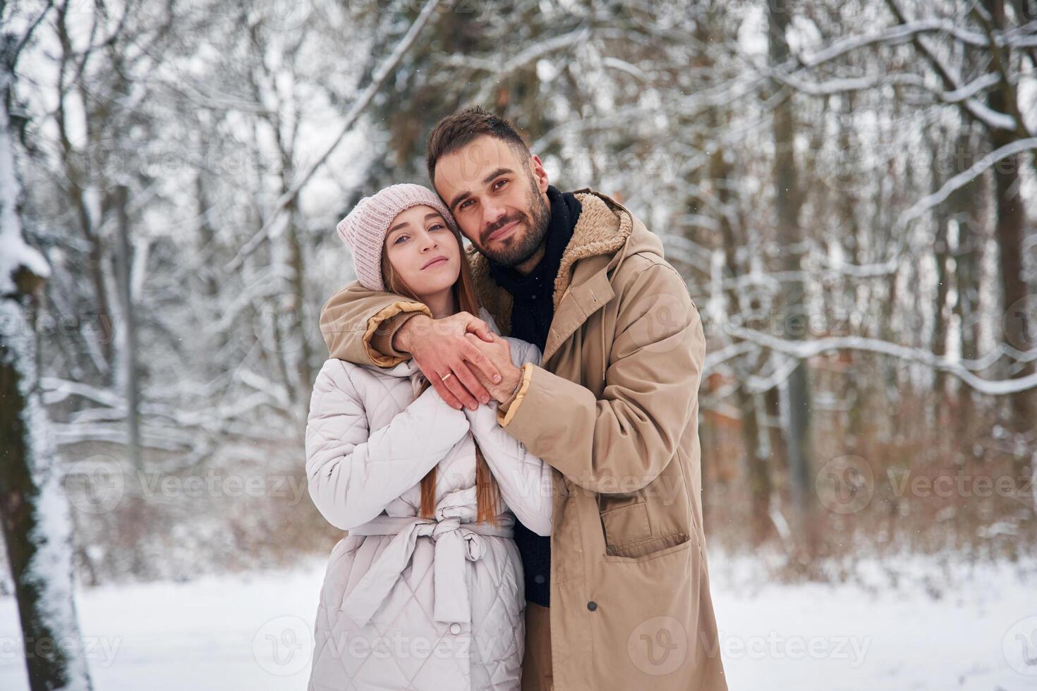 Cheerful, facial, expression. Lovely couple have a walk in the winter forest photo