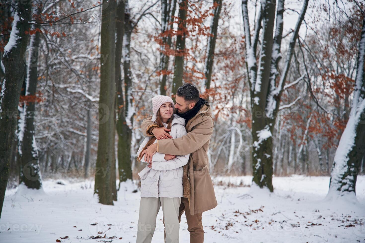 Cheerful,, facial expression. Lovely couple have a walk in the winter forest photo