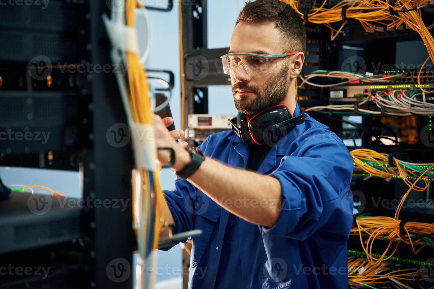 Restoring the internet connection,.,. Young man is working with equipment and wires in server room photo