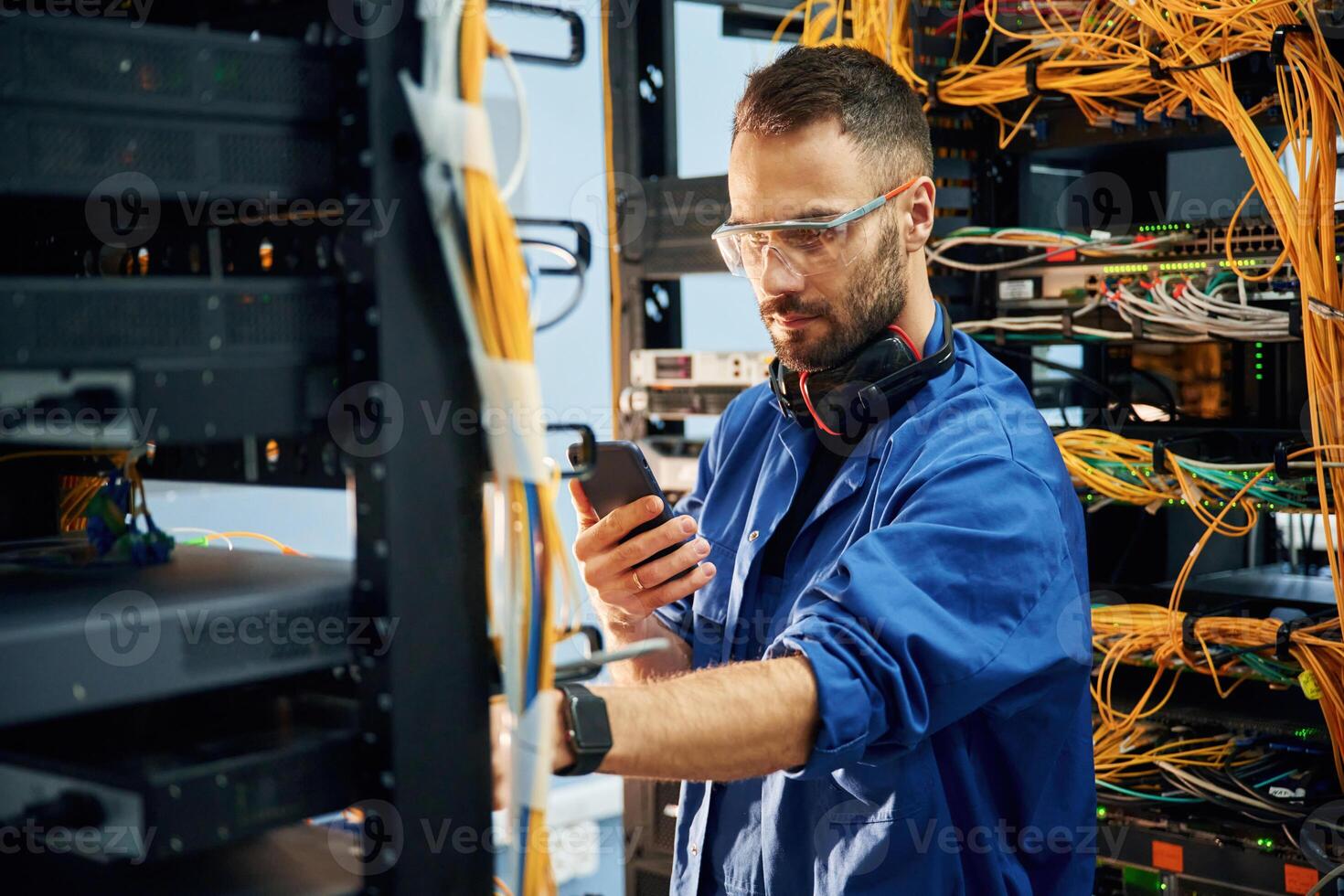 Restoring the internet connection.., Young man is working with equipment and wires in server room photo