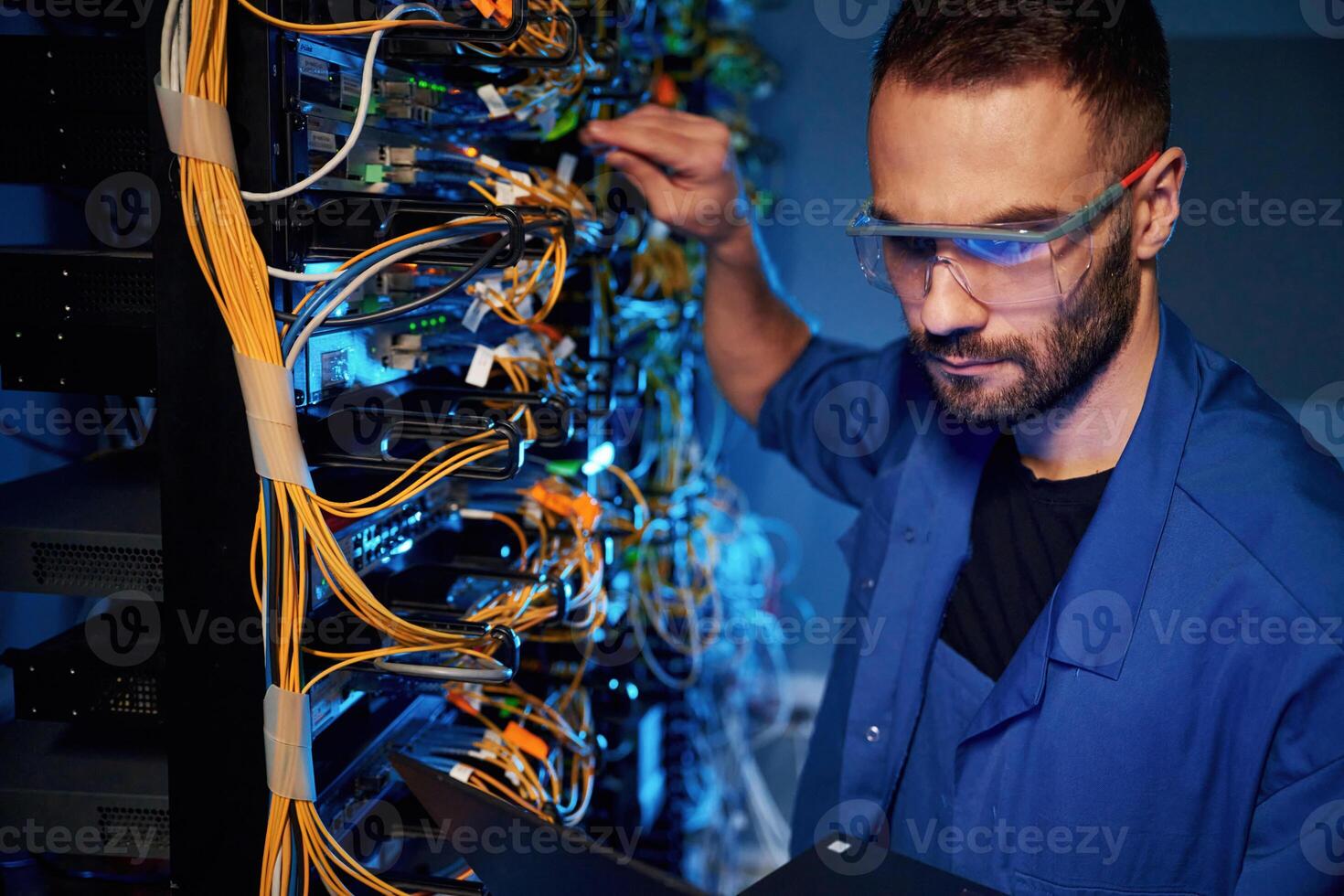 In glasses., Young ,,man is working with internet equipment and wires in server room photo