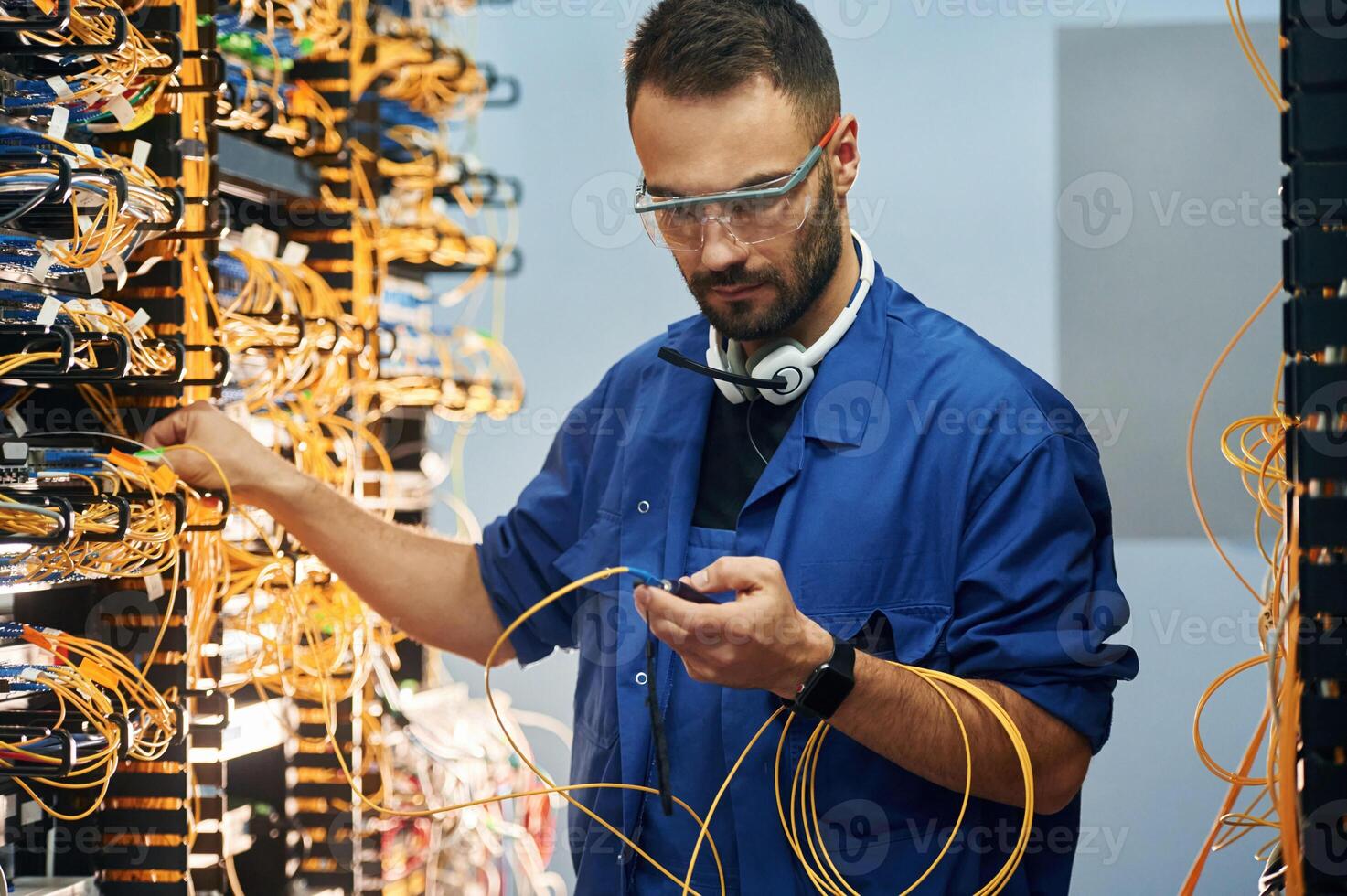 Modern, technology ,routing. Young ,man is working with internet equipment and wires in server room photo